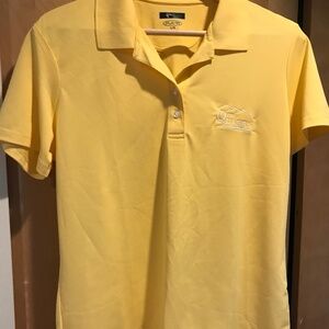 A woman’s yellow golf shirt from “The Quarry”